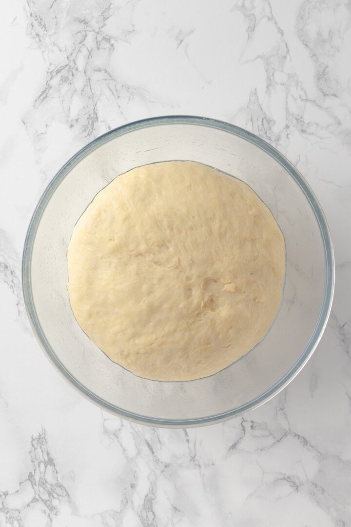 Overhead view of dough for donuts in glass bowl