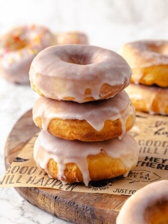 Stack of 3 air fryer donuts on parchment-lined board