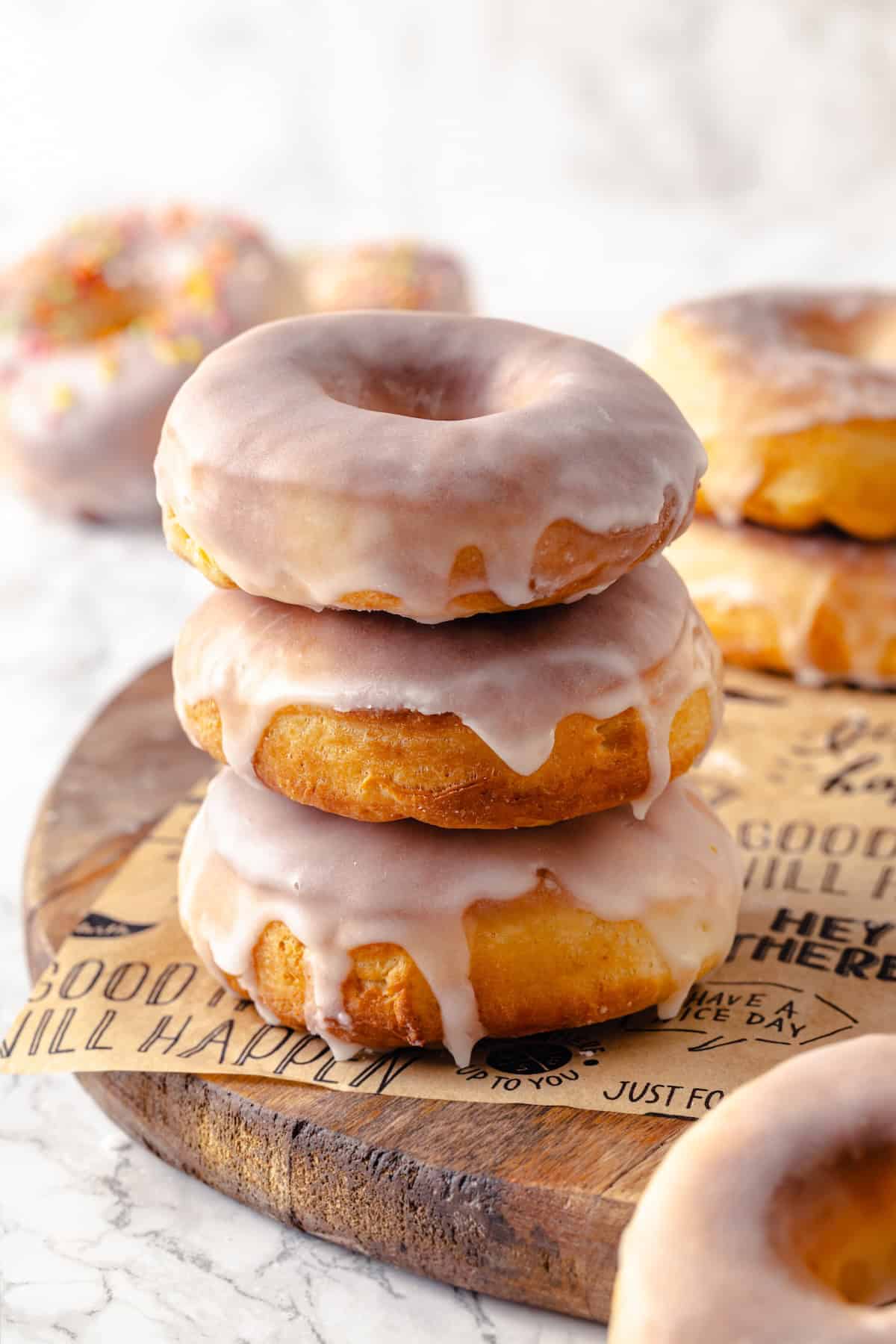 Want homemade donuts without the fuss? These glazed air fryer donuts deliver! They’re super easy to make and bake in just 5 minutes! Stack of 3 air fryer donuts on parchment-lined board