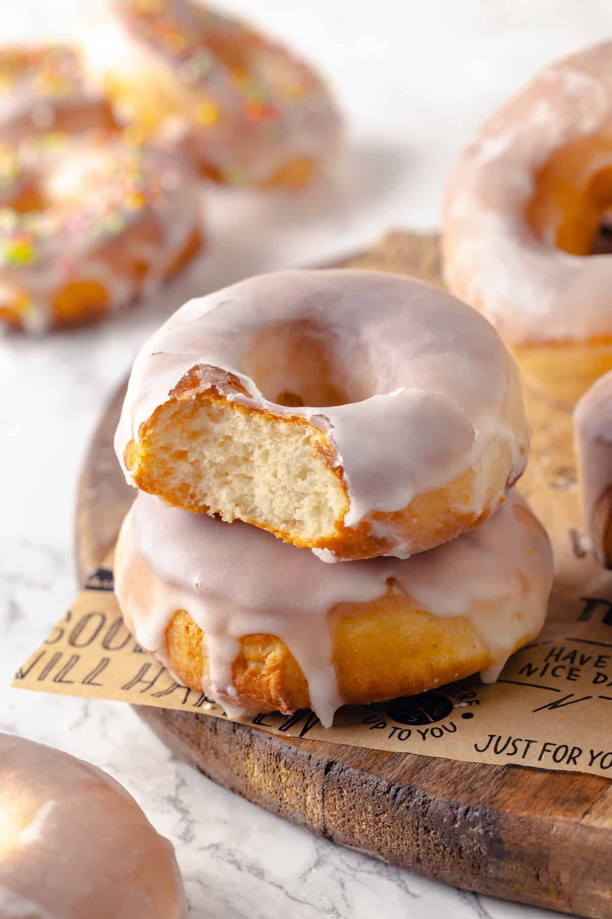 Two stacked air fryer donuts, with top donut bitten into to show airy interior