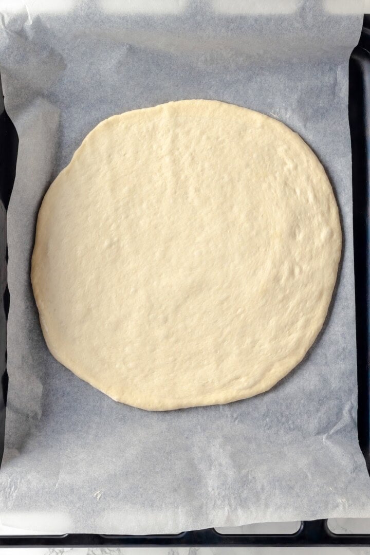 Overhead view of pizza crust on pan before adding toppings