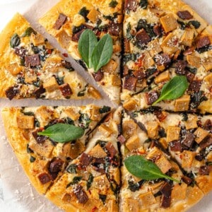 Overhead view of whole Alfredo sauce pizza cut into slices