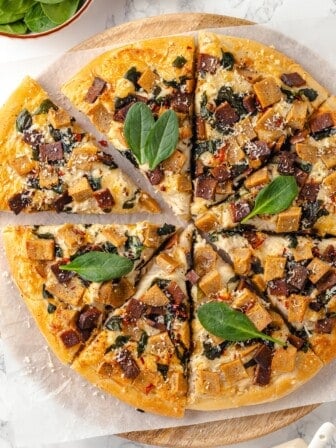 Overhead view of whole Alfredo sauce pizza cut into slices