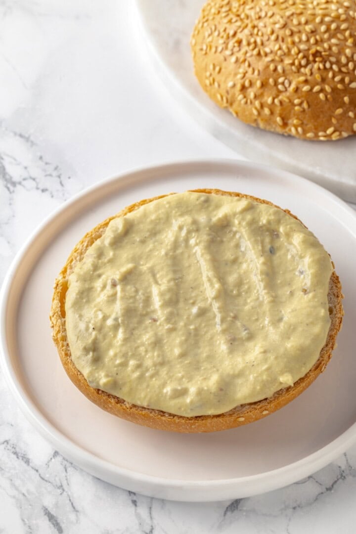 Bottom bun slathered with tahini sauce