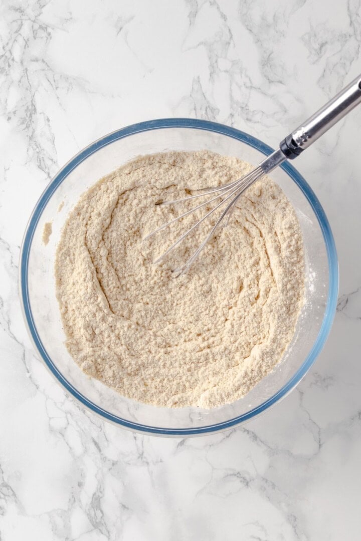 Overhead view of dry ingredients for gluten-free bagels in bowl with whisk