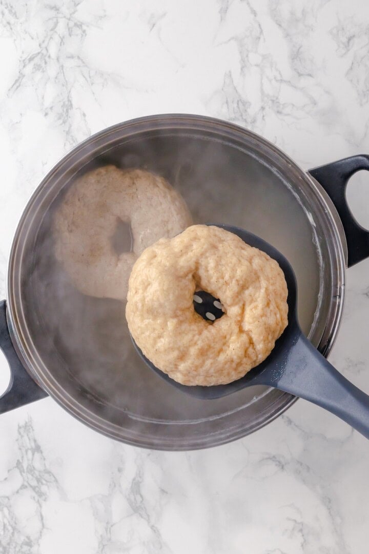 Dropping gluten-free bagel into pot of water