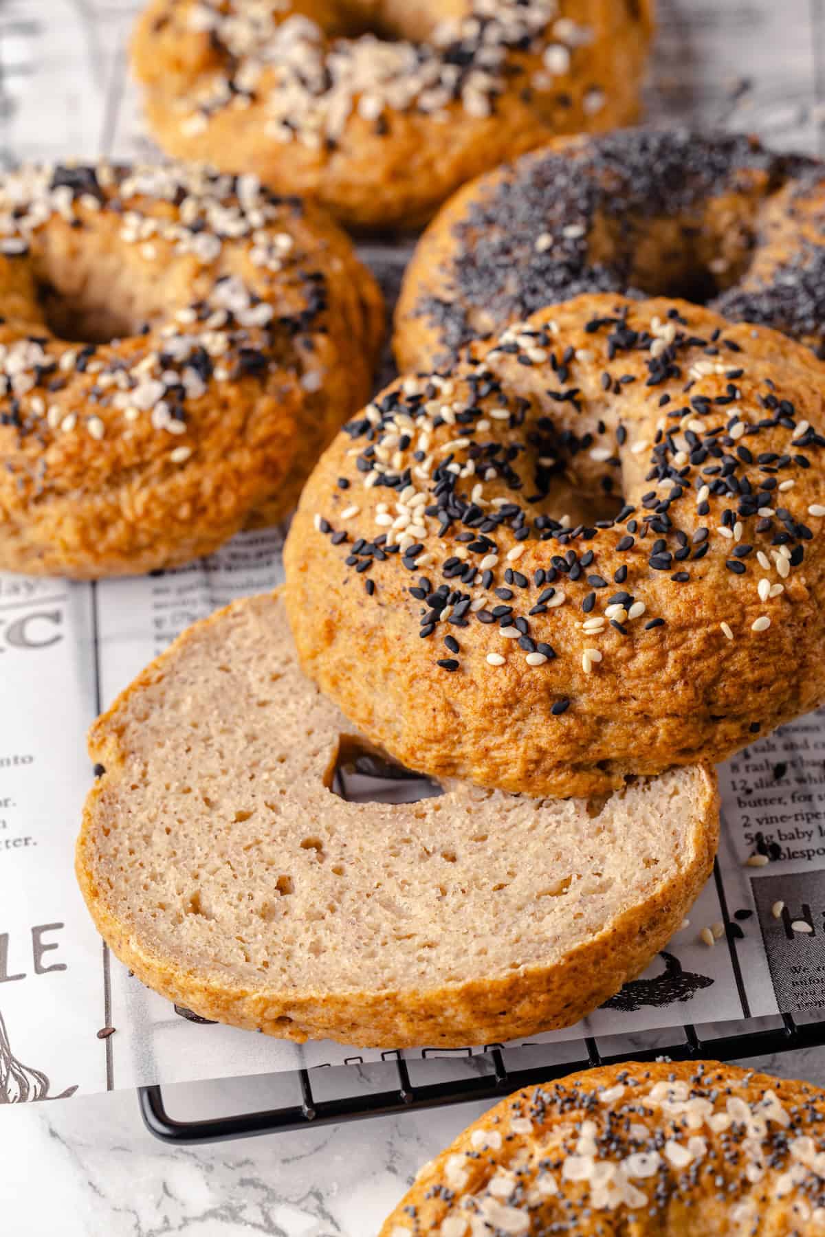 Sliced halves of a gluten-free bagel on wire rack