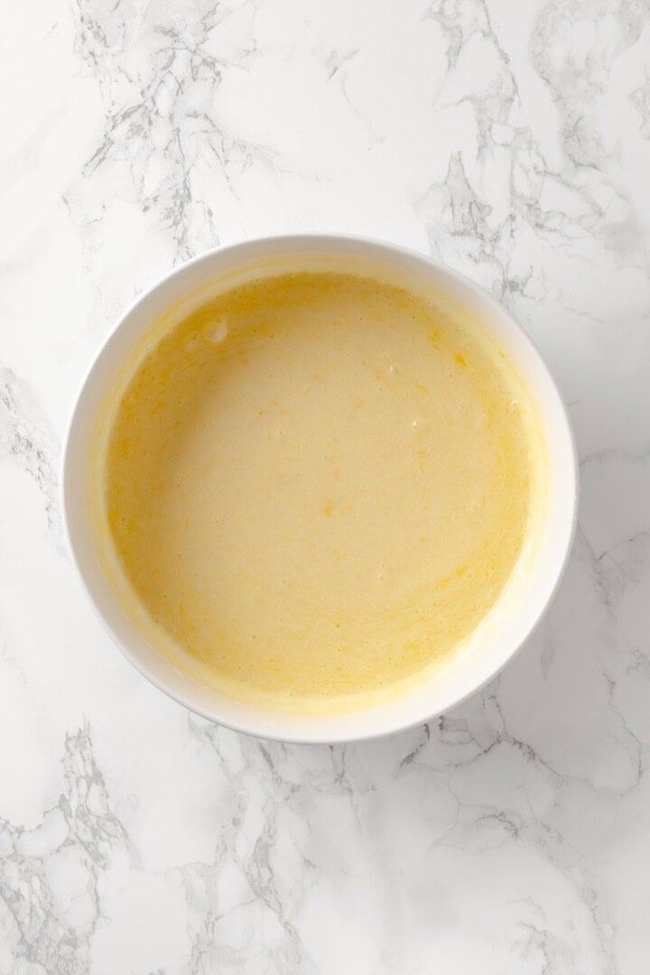 Overhead view of liquid ingredients for lemon blueberry Bundt cake in bowl