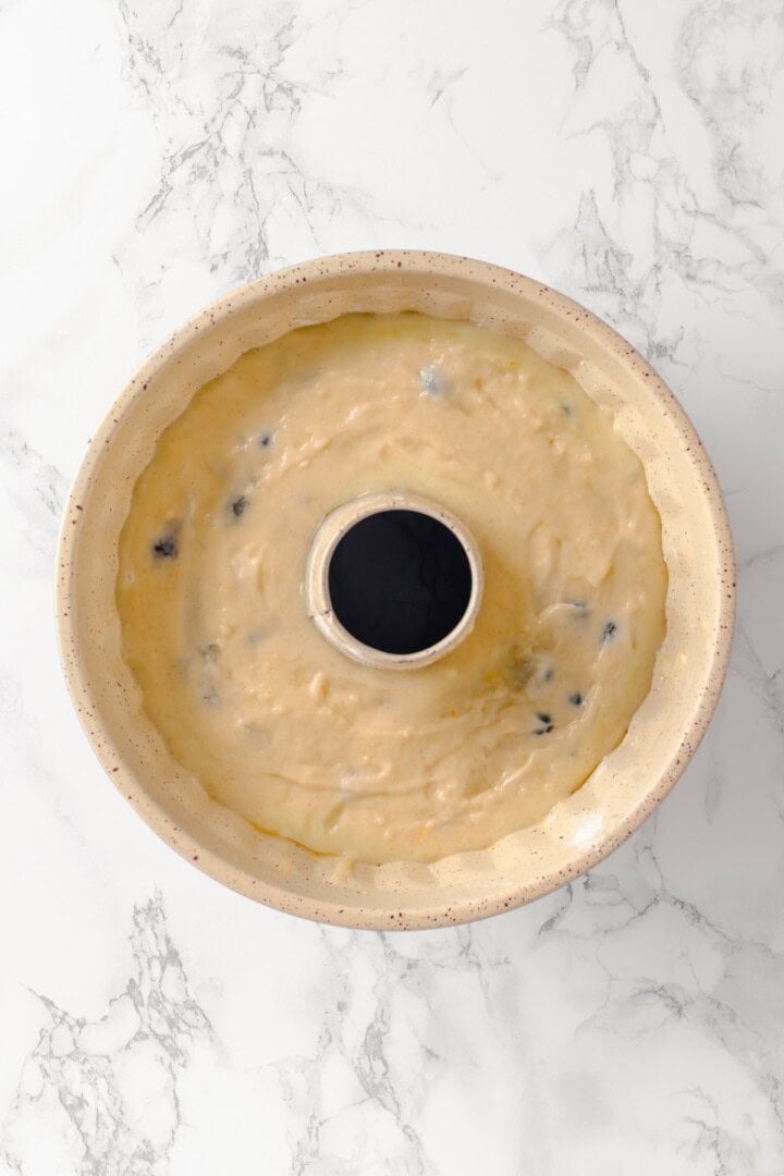 Overhead view of batter for lemon blueberry Bundt cake in pan