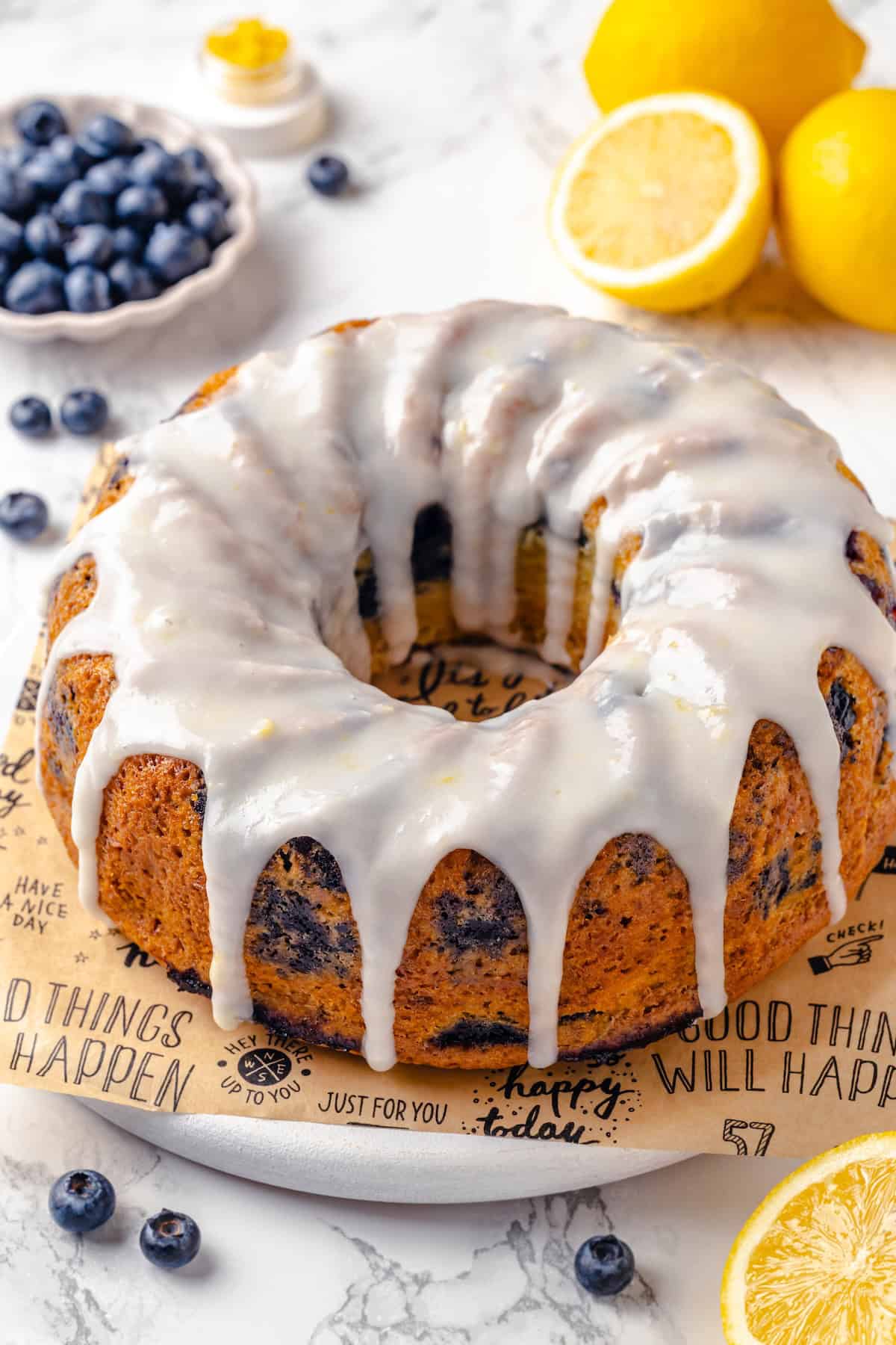 Whole lemon blueberry Bundt cake on parchment-lined platter