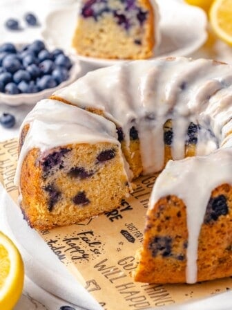 Sliced lemon blueberry Bundt cake on platter with a few pieces removed