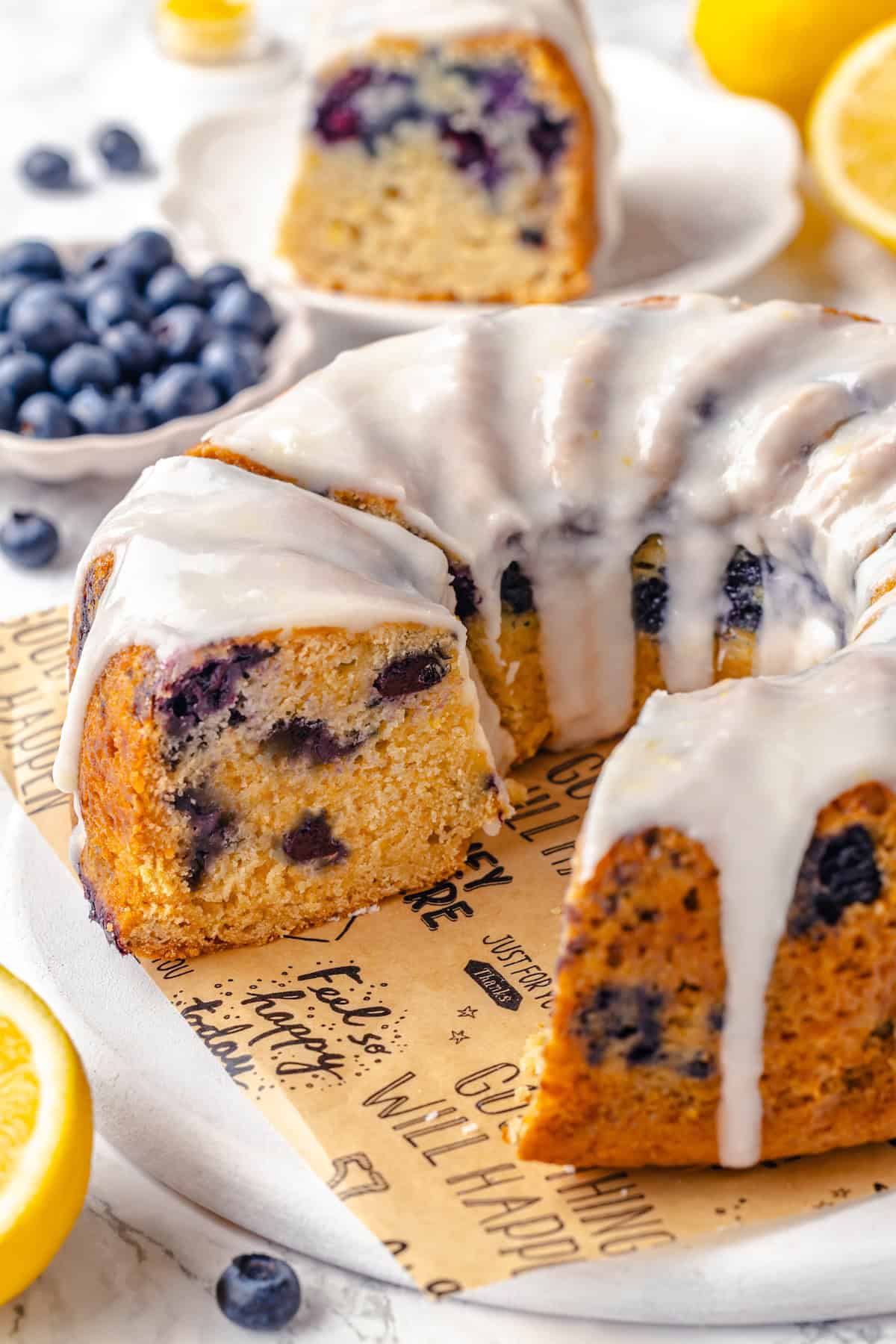 Sliced lemon blueberry Bundt cake on platter with a few pieces removed