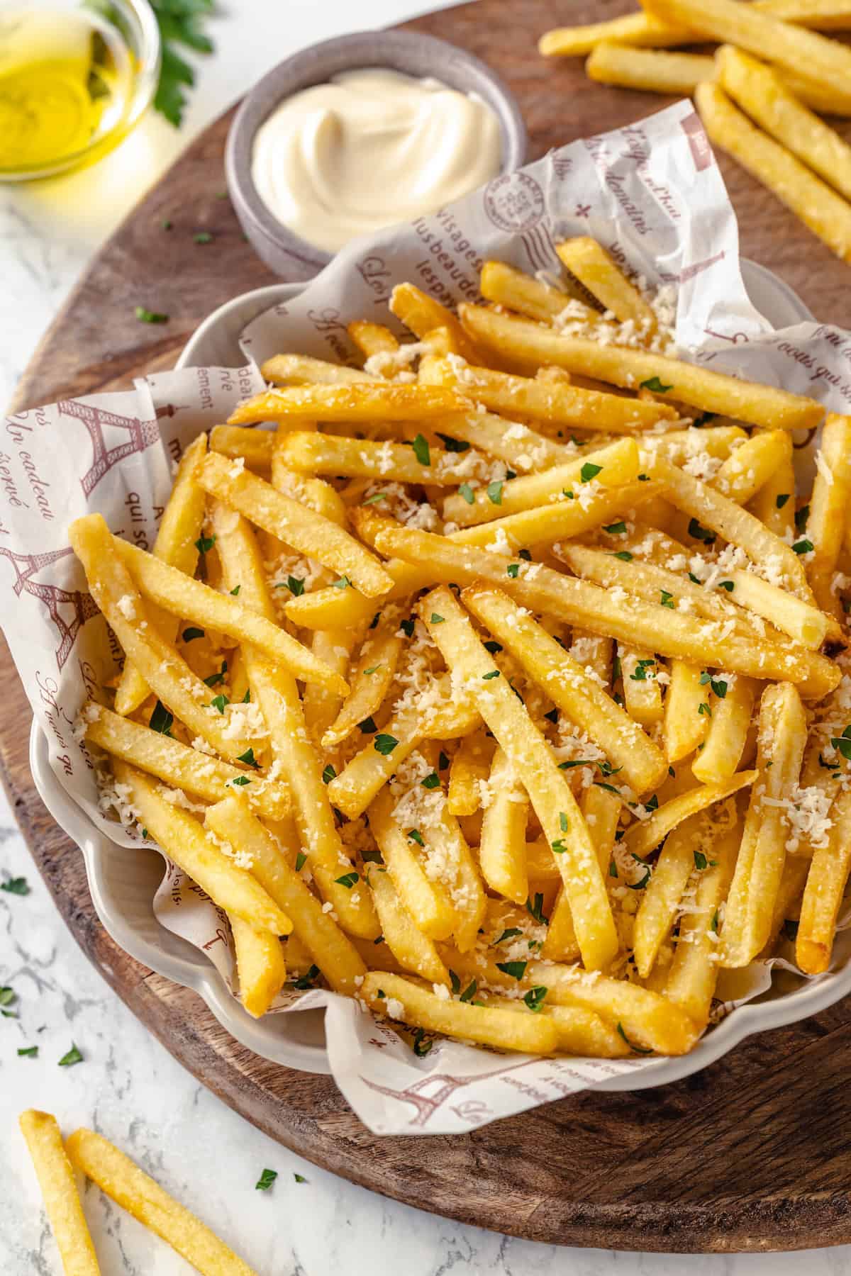 Overhead view of truffle fries in bowl set next to small bowl of aioli