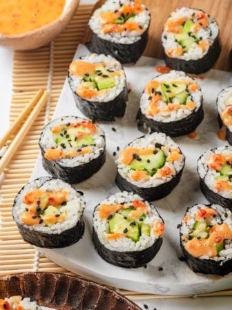 Avocado sushi rolls arranged on marble serving board