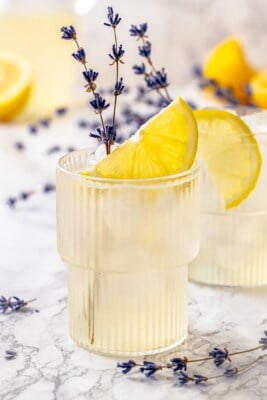 Two glasses of lavender lemonade with lemon slices and lavender sprigs