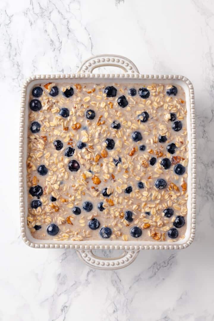 Overhead view of oatmeal and blueberry mixture in dish before baking