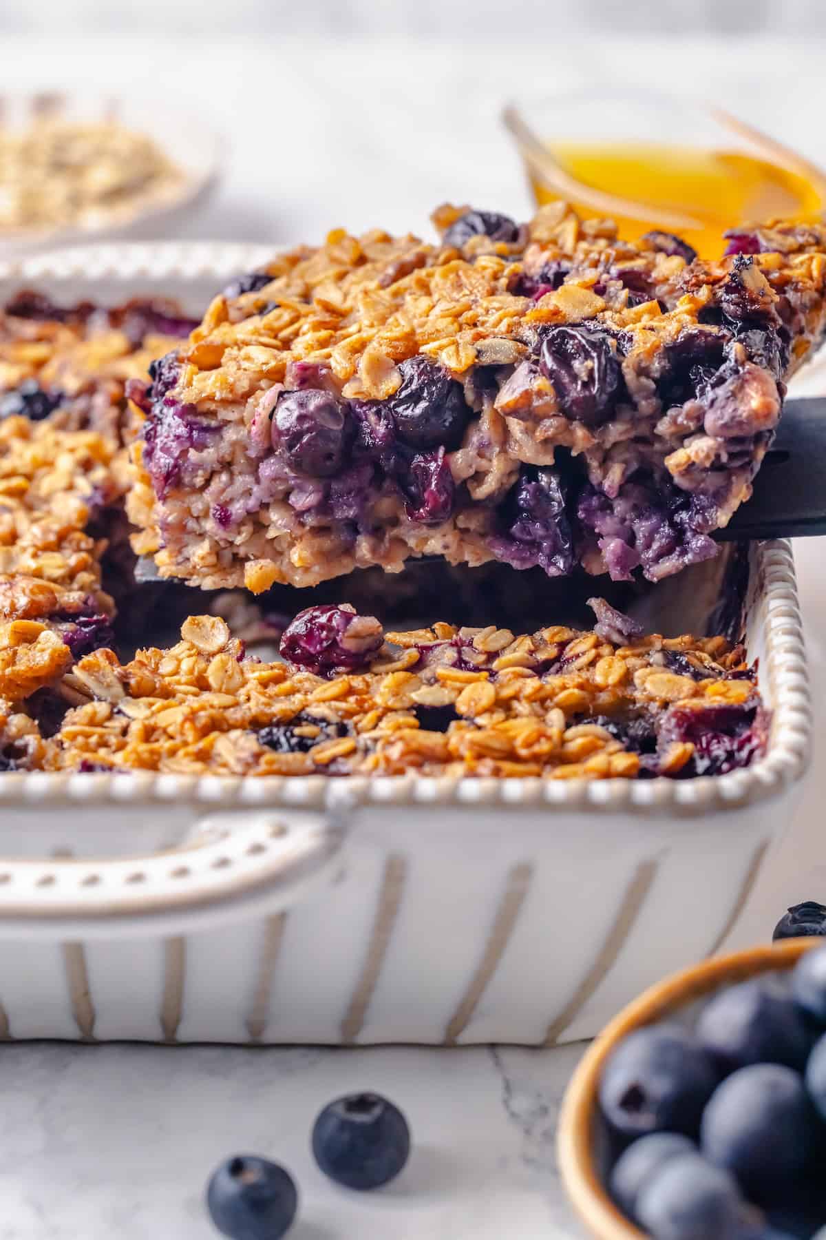 Lifting square of baked oatmeal from baking pan