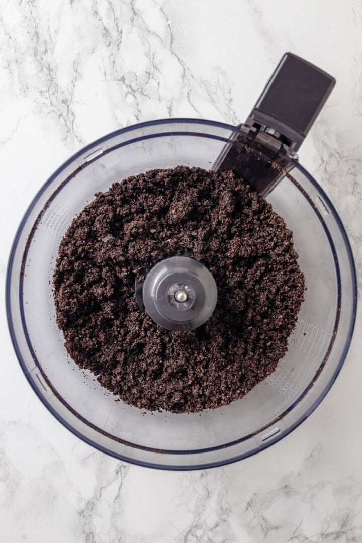 Overhead view of Oreo crumbs in food processor bowl