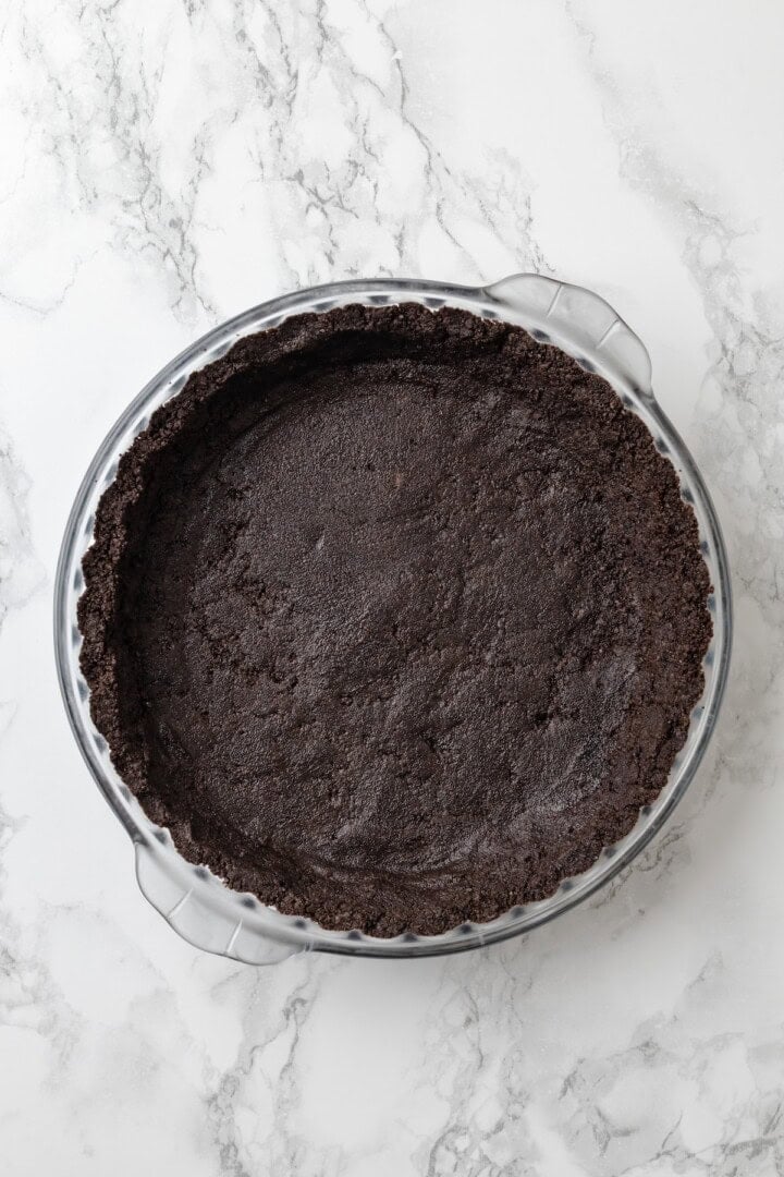 Overhead view of Oreo crumb mixture pressed into pie plate