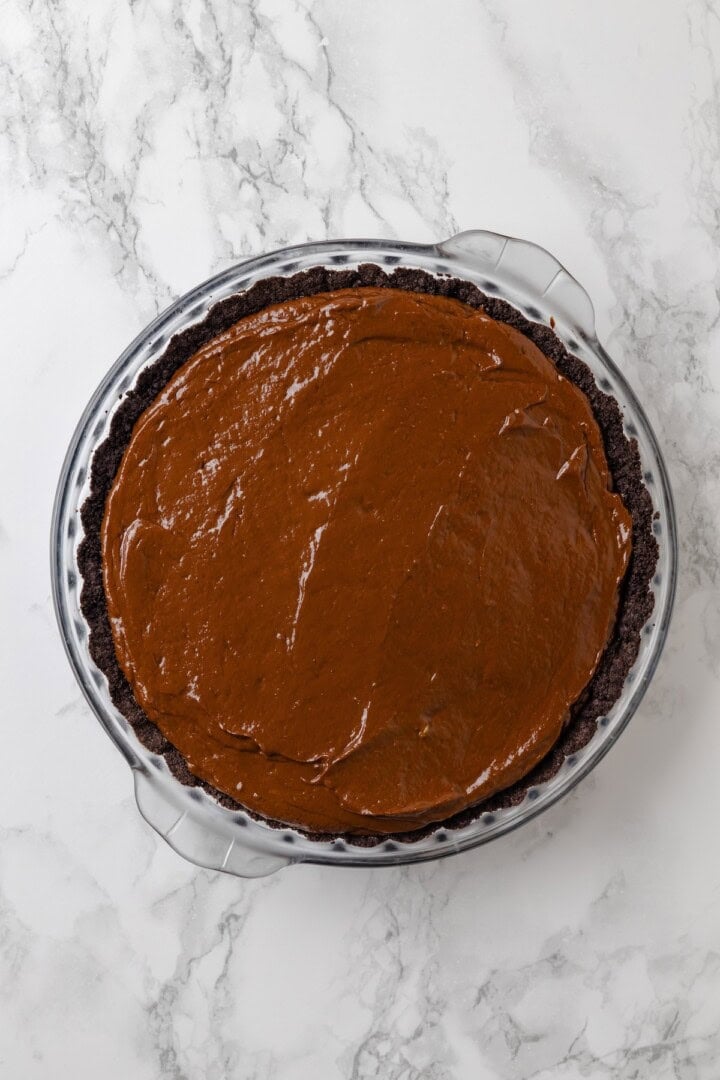 Overhead view of chocolate mousse filling added to pie crust