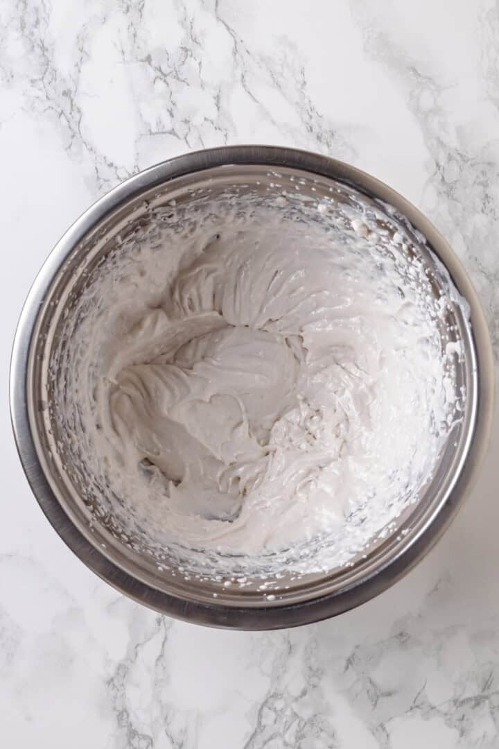 Overhead view of whipped coconut cream in mixing bowl