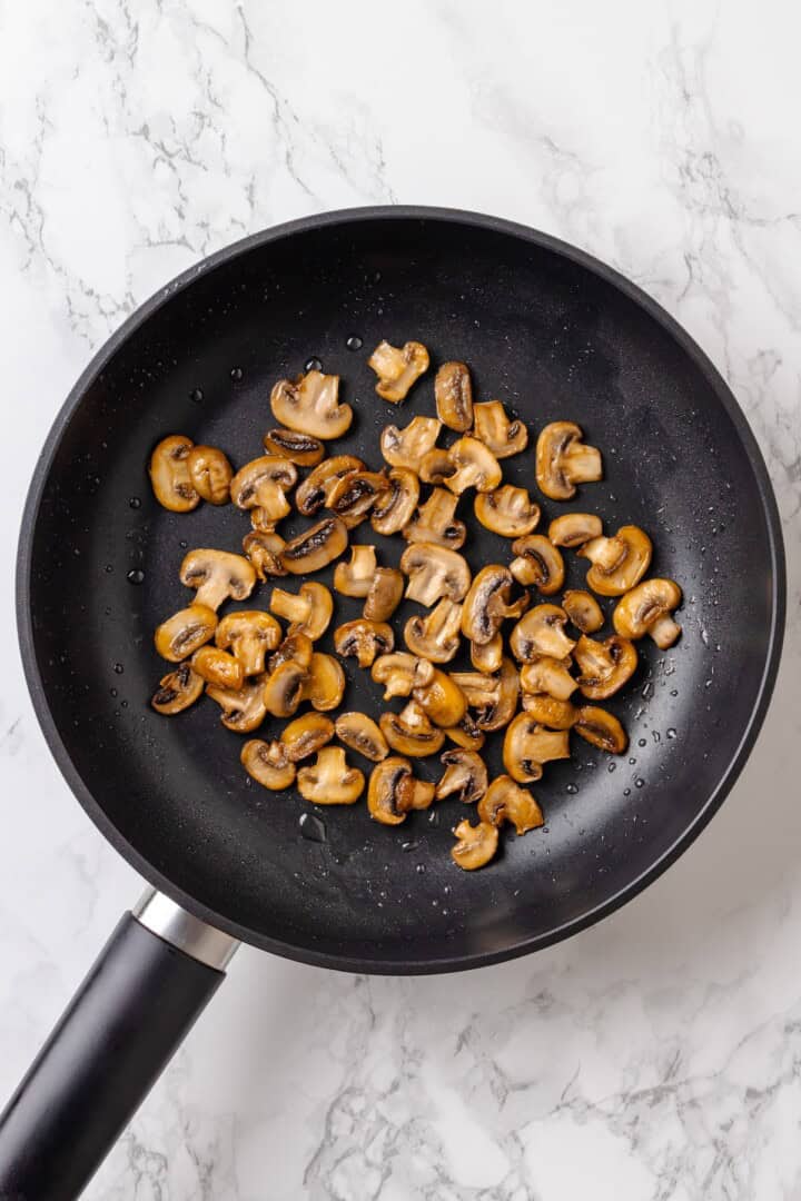 Overhead view of sauteed mushrooms in skillet
