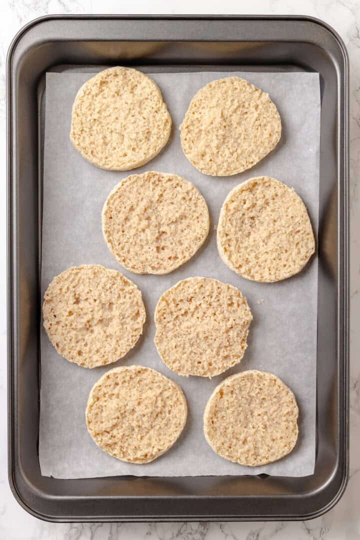 Overhead view of English muffin halves on sheet pan