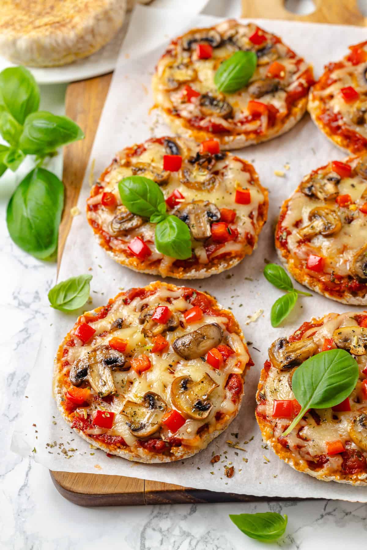 English muffin pizza is the perfect way to get your pizza fix in convenient personal-sized portions. This vegan version is easy and delicious! English muffin pizzas topped with red bell pepper and mushrooms