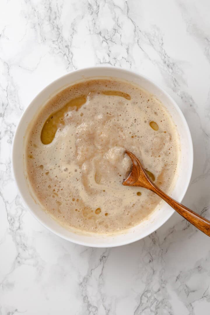 Stirring wet ingredients for gluten-free English muffins in bowl
