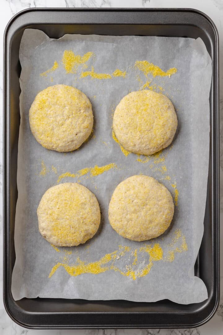 Overhead view of shaped gluten-free English muffin dough on pan
