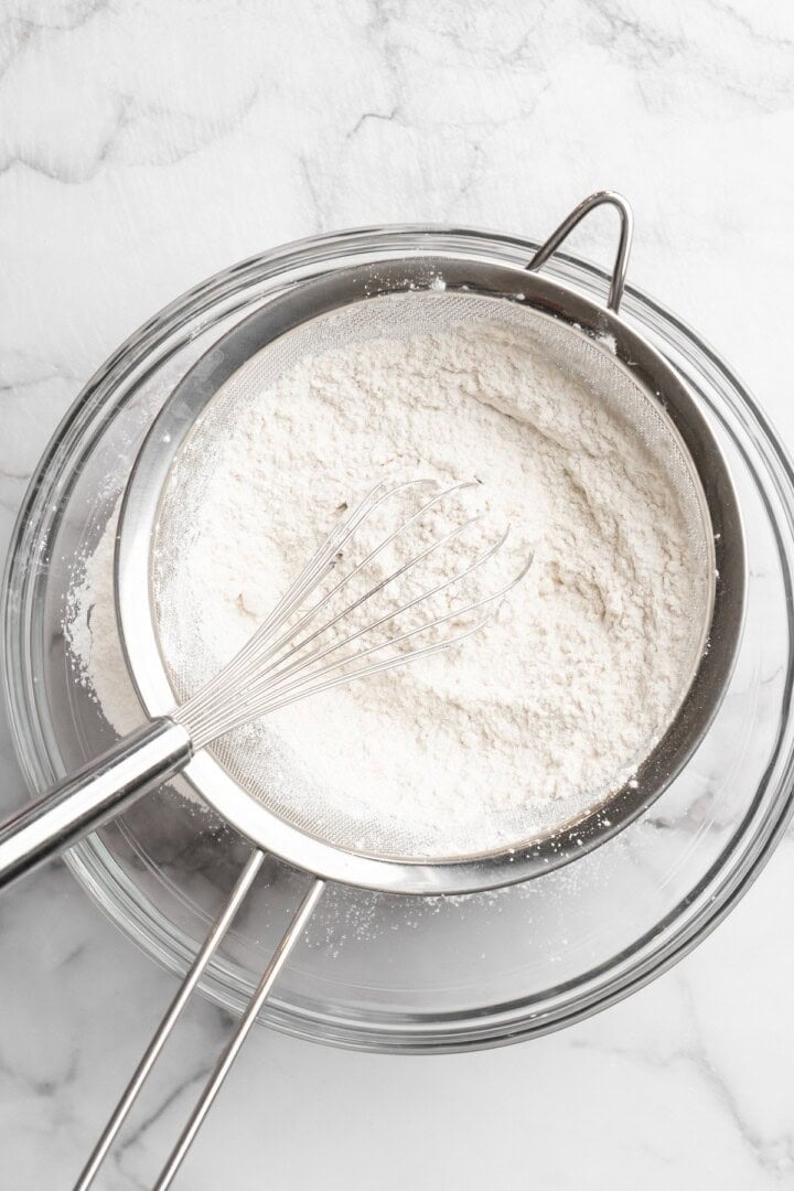 Sifting dry ingredients into mixing bowl