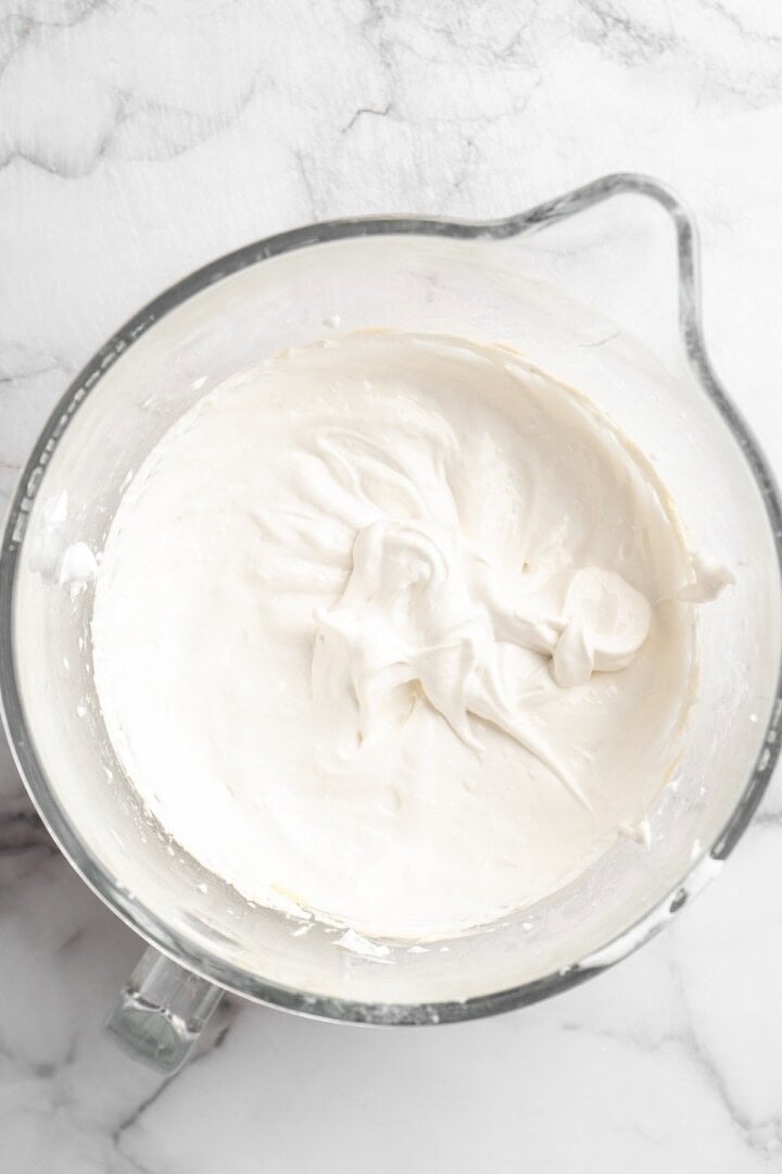 Overhead view of aquafaba mixture in glass mixing bowl