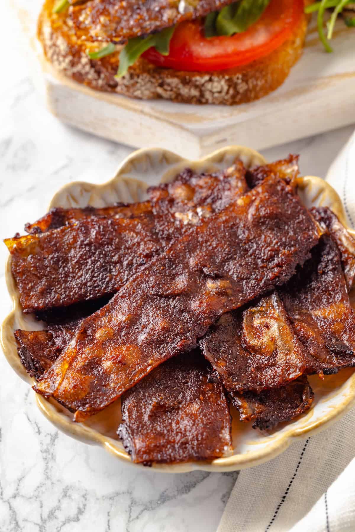 Rice paper is the secret for ultra crispy vegan bacon! This recipe is smoky, sweet, and savoury, and it's incredibly easy to make too. Crispy rice paper bacon in bowl