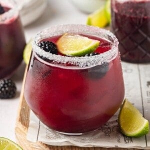 Blackberry margarita in glass with salted rim and fresh berries and lime