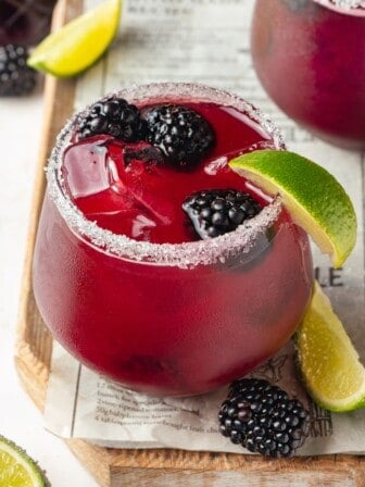 Salted glass with blackberry margarita and fresh berries for garnish