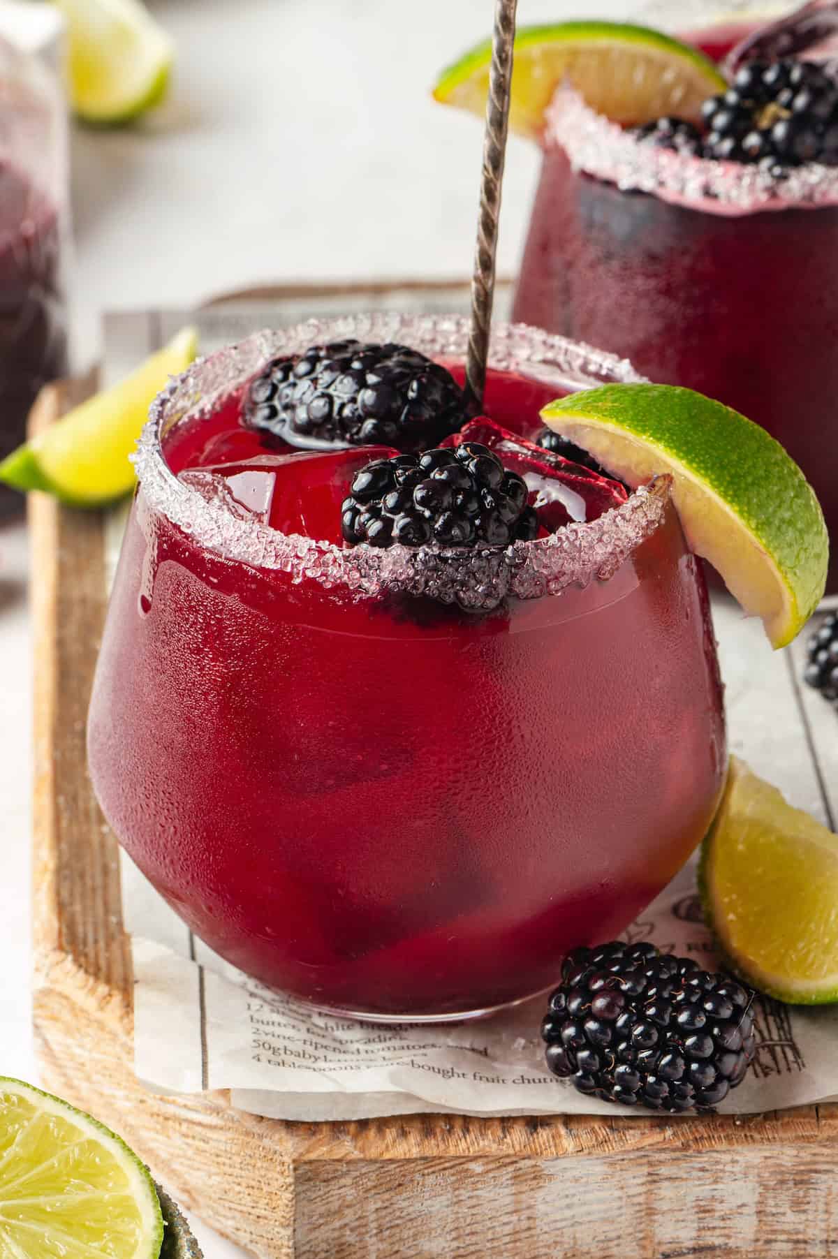 Homemade blackberry margarita in glass with fresh berries and lime wedge
