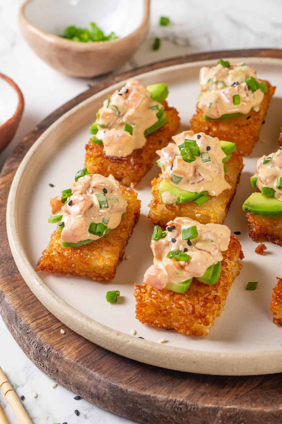 Plate of crispy rice cakes topped with creamy vegan tuna