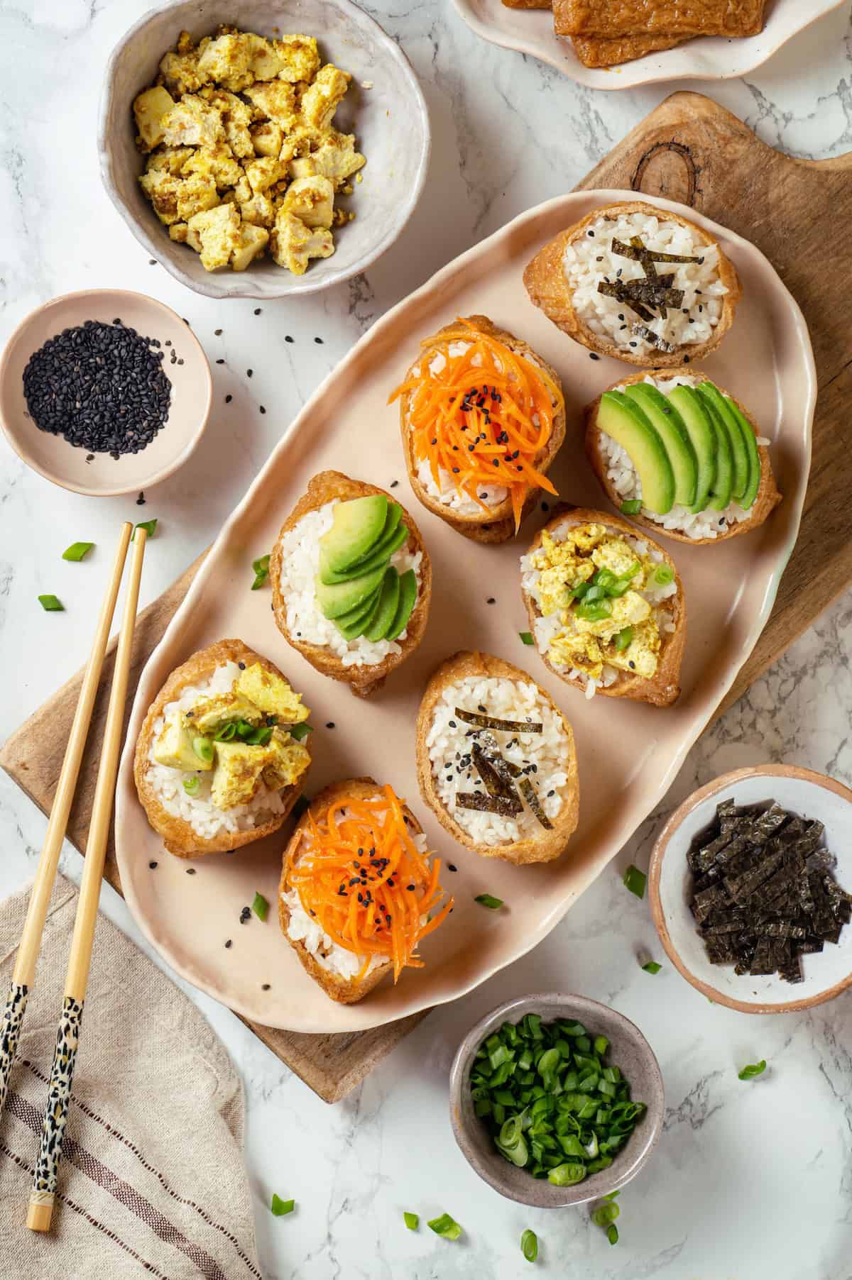 Overhead view of vegan inari sushi on platter with various toppings
