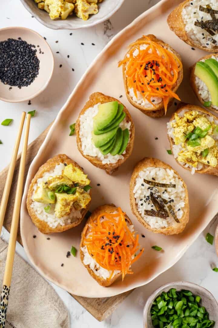 Overhead view of inari sushi on platter with vegan toppings
