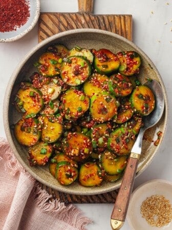 Overhead view of Korean cucumber salad in bowl with spoon