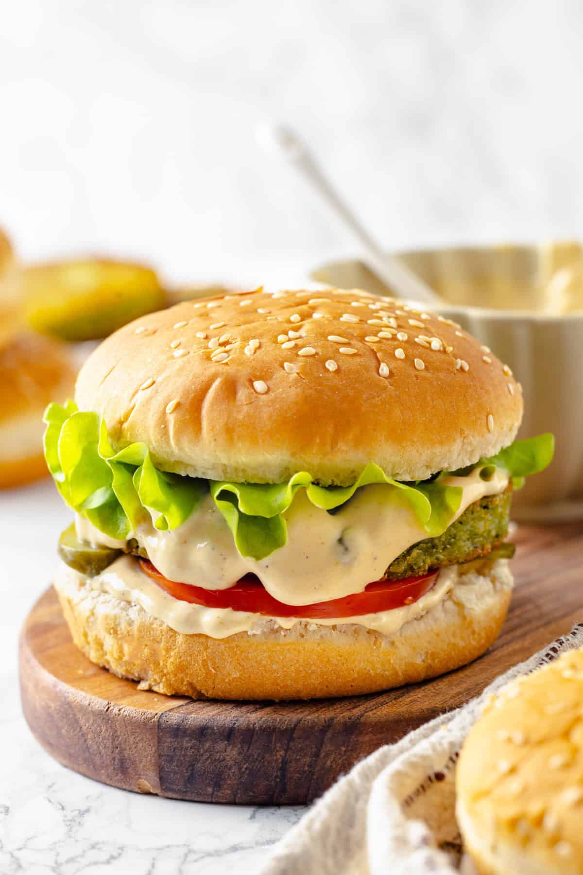 This easy burger sauce is made with pantry staples, which means you can mix it up anytime you need it for burgers, fries, wings and more! Vegan burger on wooden board topped with burger sauce