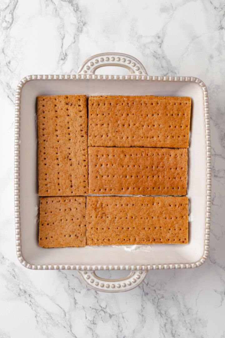 Graham crackers layered in dish for icebox cake
