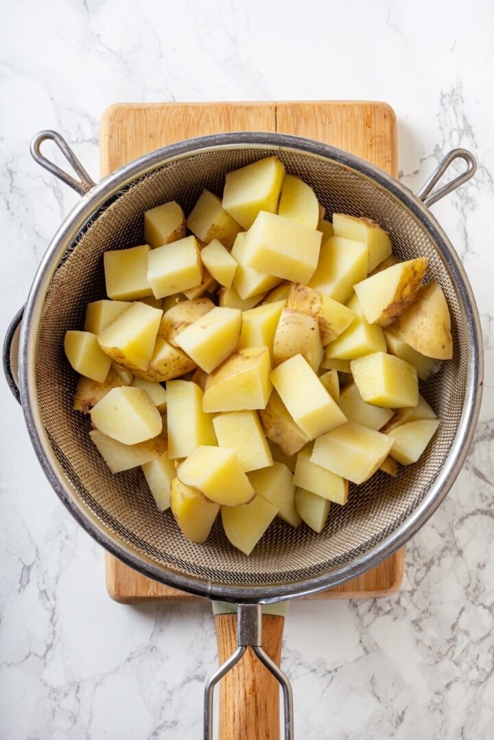 Overhead view of diced potatoes in colander