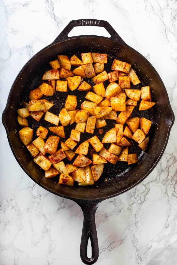Overhead view of cooked breakfast potatoes in skillet