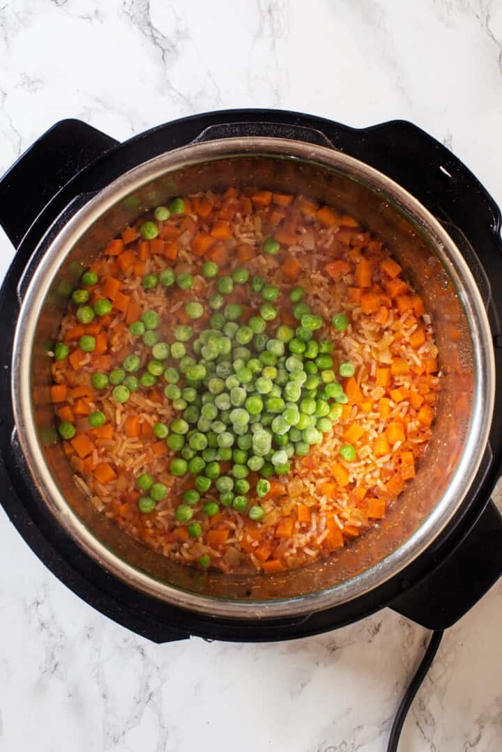 Overhead view of frozen peas added to Instant Pot Mexican rice