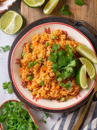 Overhead view of Instant Pot Mexican rice in bowl with cilantro and lime wedges