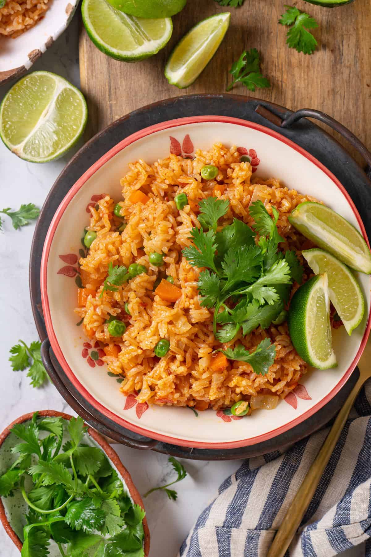 Overhead view of Instant Pot Mexican rice in bowl with cilantro and lime wedges