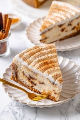 Two plates with slices of cinnamon roll cheesecake