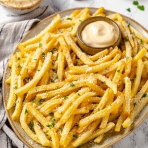 Platter of vegan garlic fries with bowl of aioli