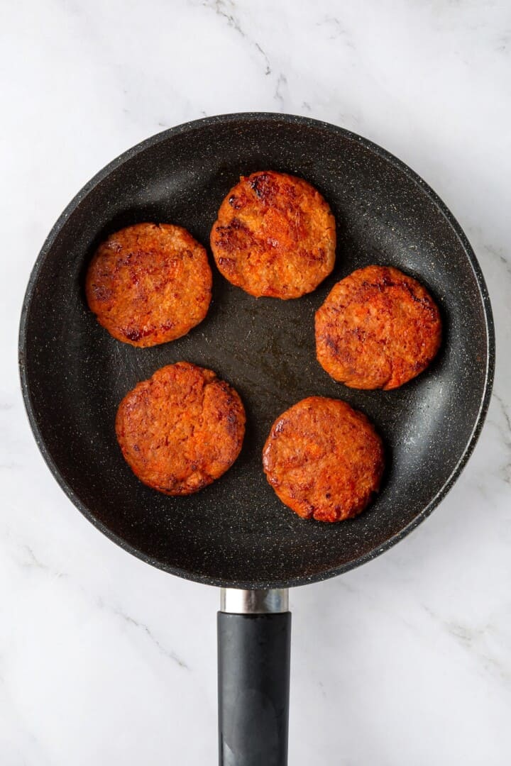 Overhead view of cooked vegan sausage in skillet
